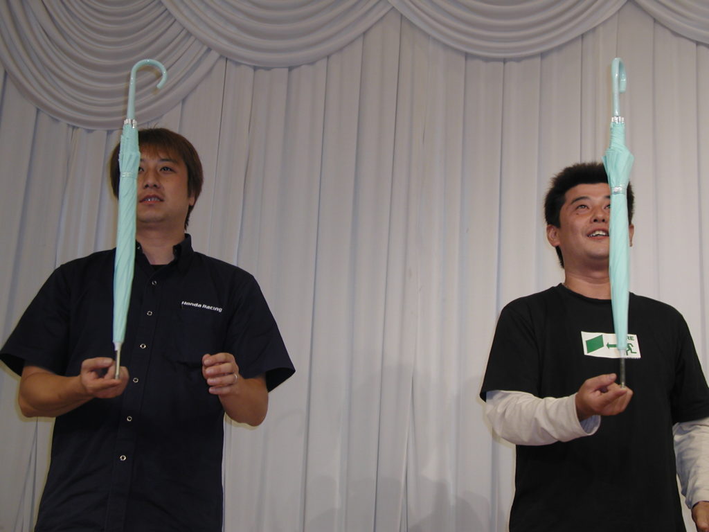 恒例のゲーム大会。今年は「指の上で傘立て」。隣りにいるのは、「TUBE」のメンバーでドライバーとして参戦している松本玲二選手。